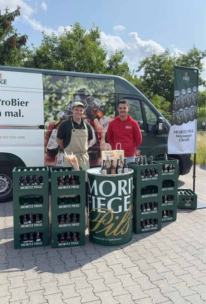 Twee personen bij een Moritz Fiege-proeverijkraam in de buitenlucht