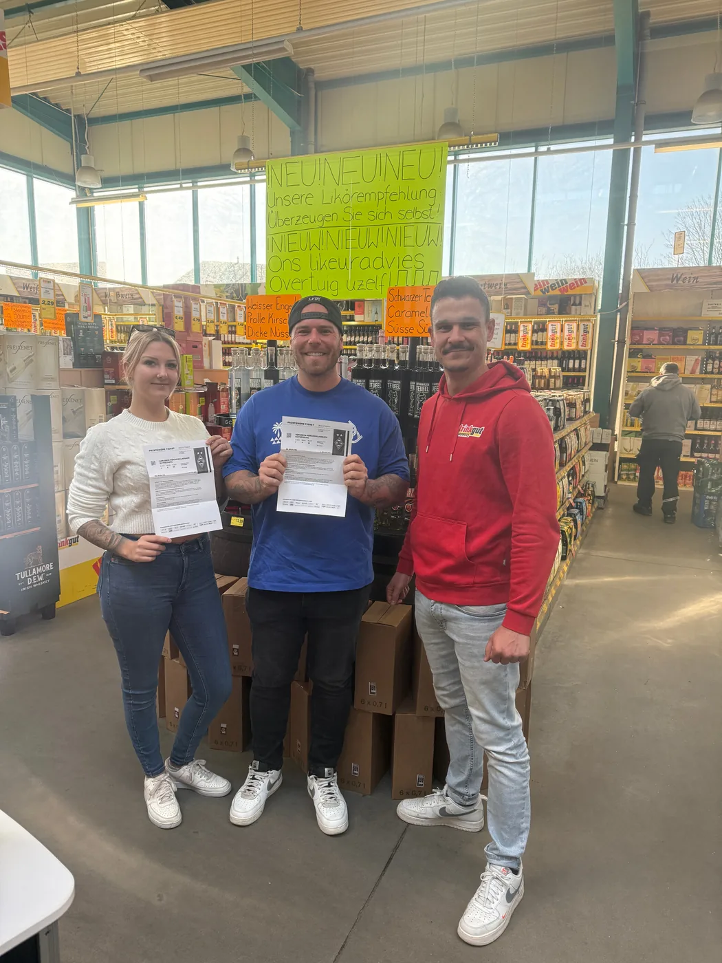 Drie personen met gewonnen toegangskaarten in de winkel